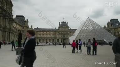 超摄镜头的游客和游客走在卢浮宫附近，来到金字塔的主入口